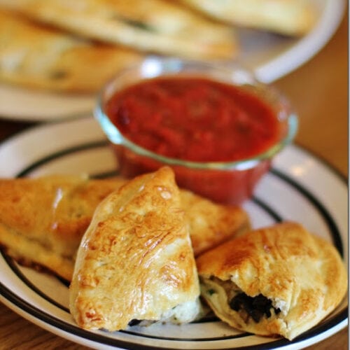 Easy Calzones served on a round white plate on a wood table