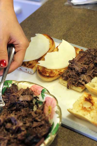 shredded beef in a bowl, hoagie or french rolls with cheese