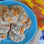 Pumpkin Spice Oatmeal Cookies sitting on a round blue plate next to a package of pumpkin spice chips from the store