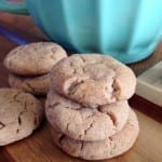Stack of Cream cheese snicker doodle cookies on a wood table in front of white bowl