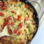 One Skillet Cheeseburger Pasta in a pan with wooden spoon sitting on wood tray
