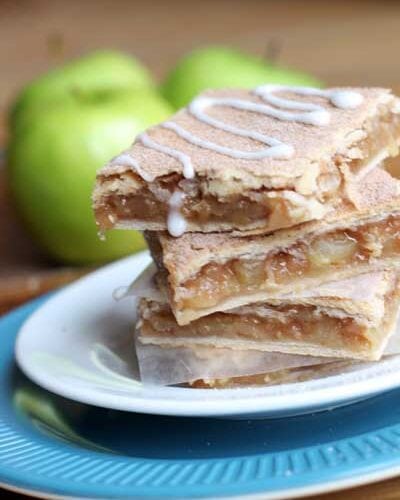 Apple Pie Bars text overly on an image with apple pie bars on a blue plate
