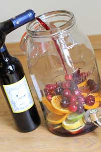 Sprarkling Sangria being made in a glass jar full of fruit