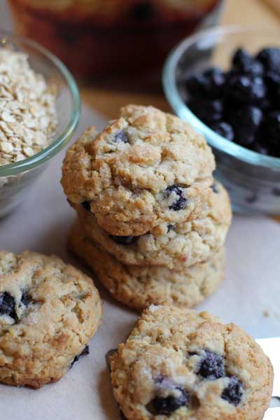 Blueberry Muffin Cookies stacked next to bowls of blueberries