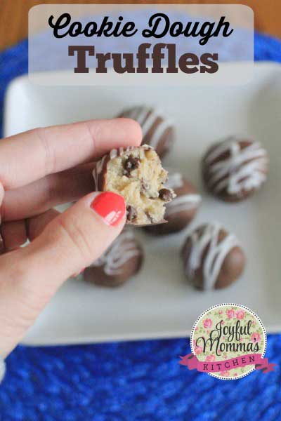 No Bake Cookie Dough Truffles text overlay with a hand holding a truffle already bitten above a white plate with more truffles