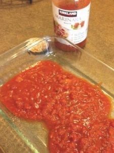 glass pan with marinara sauce poured inside