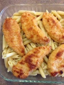 Breaded Chicken on top of noodles in a glass pan