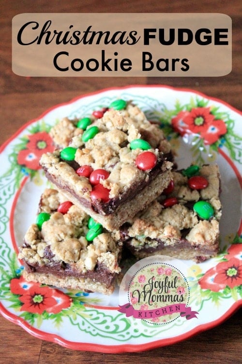 Layered cookie bars with red and green candies on a plate