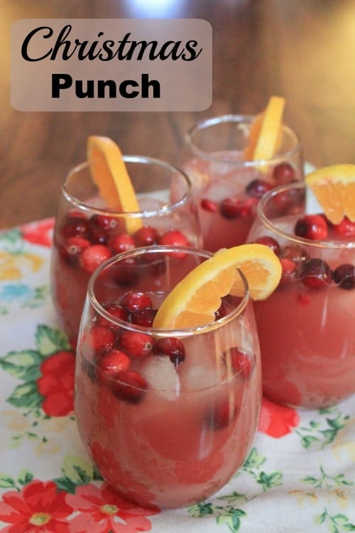 Christmas Punch Text with red fruity beverage in glas sitting on christmas tablecloth