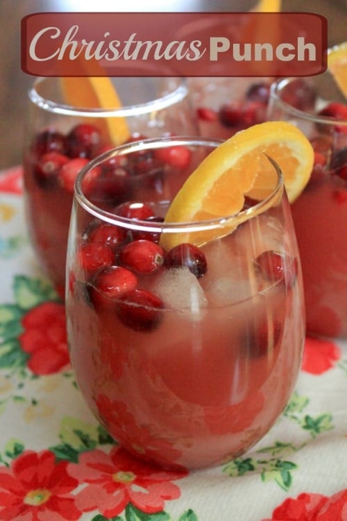 Christmas Punch Text with red fruity beverage in glas sitting on christmas tablecloth