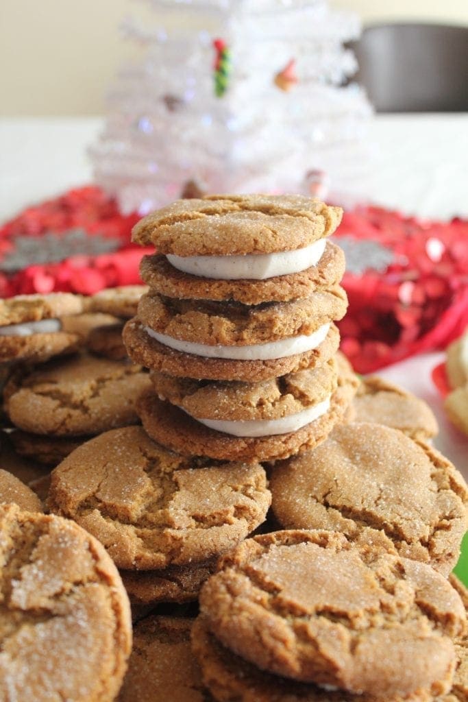 Stack of 3 sandwich cookies on a platter filled with cookies and a red background