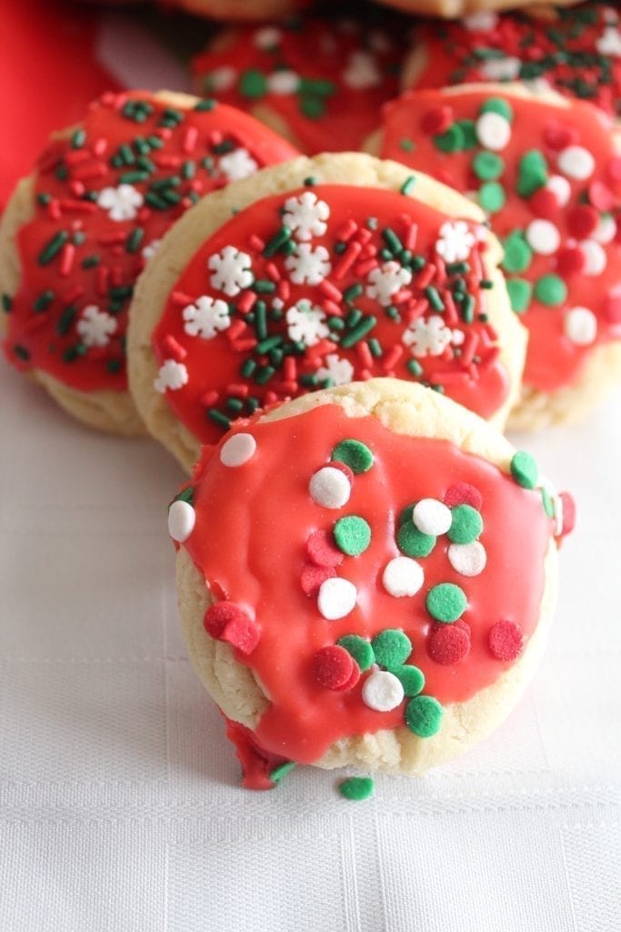 Round sugar cookies with red frosting and sprinkles