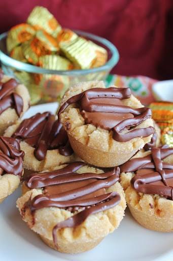 Peanutbutter cookies with a peanut butter cup candy and chocolate drizzle