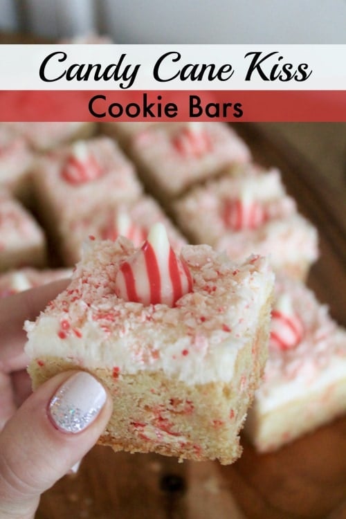 Hand holding a sugar cookie bar with peppermint frosting and a peppermint candy kiss and sprinkles