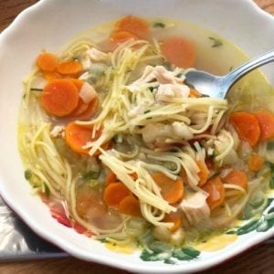 Chicken Noodle Soup in a bowl being scooped with a spoon