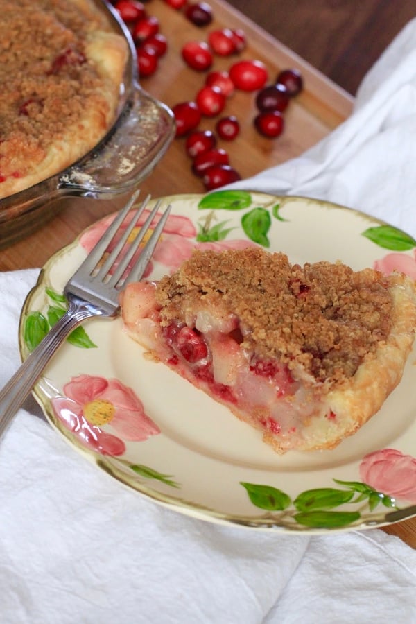 Cranberry Pear Crumb Pie on desert rose plate with cranberries in the background