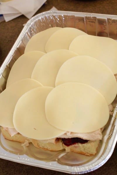 Tin pan with provolone cheese over turkey sliders