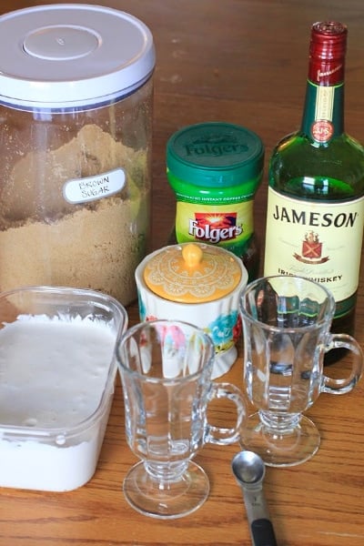 Ingredients to make Authentic Irish Coffee set on a wood table