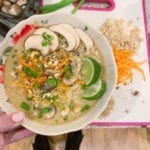 Spicy Thai Vegetable Ramen in a bowl held above a cutting board with all the ingredients