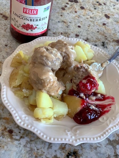 CopyCat IKEA Swedish Meatballs on a white plate next to a jar of Lingonberries
