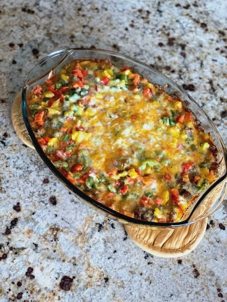 Make-Ahead Egg Bake fresh from the oven sitting in an oval glass pan on the counter