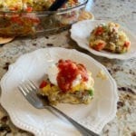 Make-Ahead Egg Bake served with sour cream and Salsa sitting on a white plate with fork