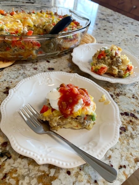Make-Ahead Egg Bake served with sour cream and Salsa sitting on a white plate with fork