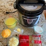 A pressure cooker, and all the ingredients needed for mac and cheese sitting together on a counter