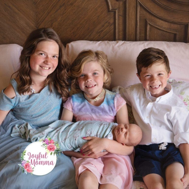 four wonderful children all sitting on mom and dad's bed