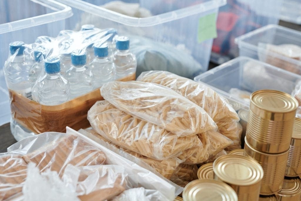 Canned goods, pagages of pasta and water bottles.
