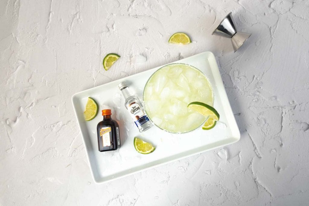 top view of margarita ingredients on a white plate set on a white countertop