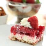 plate with layered strawberry jello, cream cheese filling, and pretzel crust