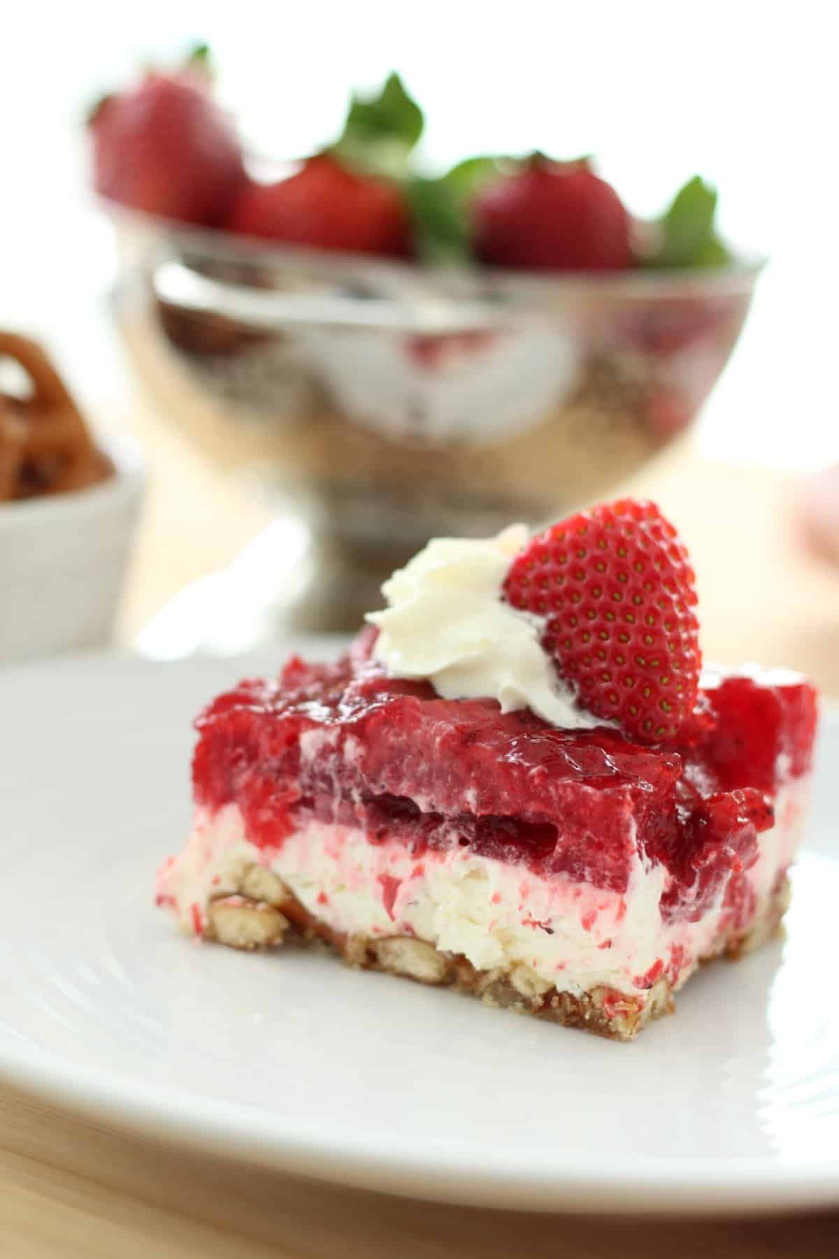 plate with layered strawberry jello, cream cheese filling, and pretzel crust