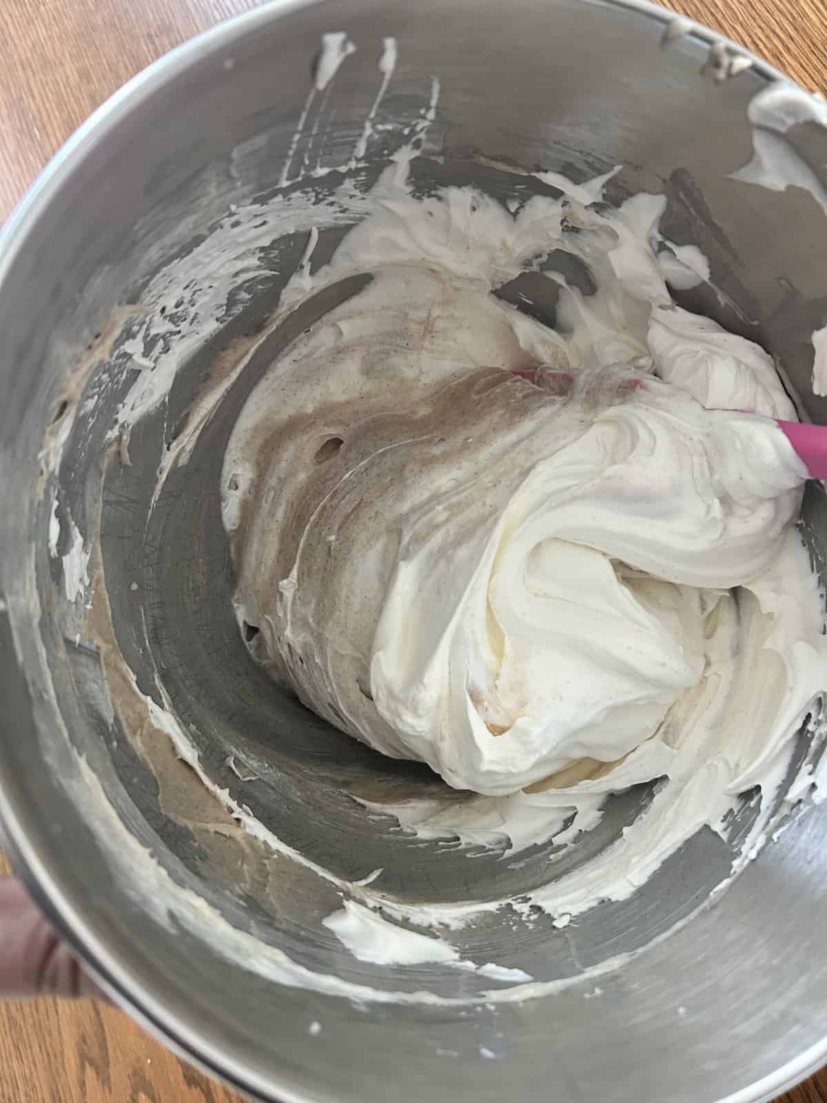 stirred and swirled cinnamon cream filling in a large metal bowl